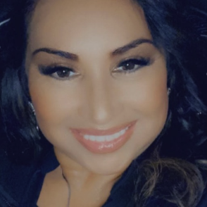 Smiling woman with long dark hair and natural makeup, looking directly at the camera.