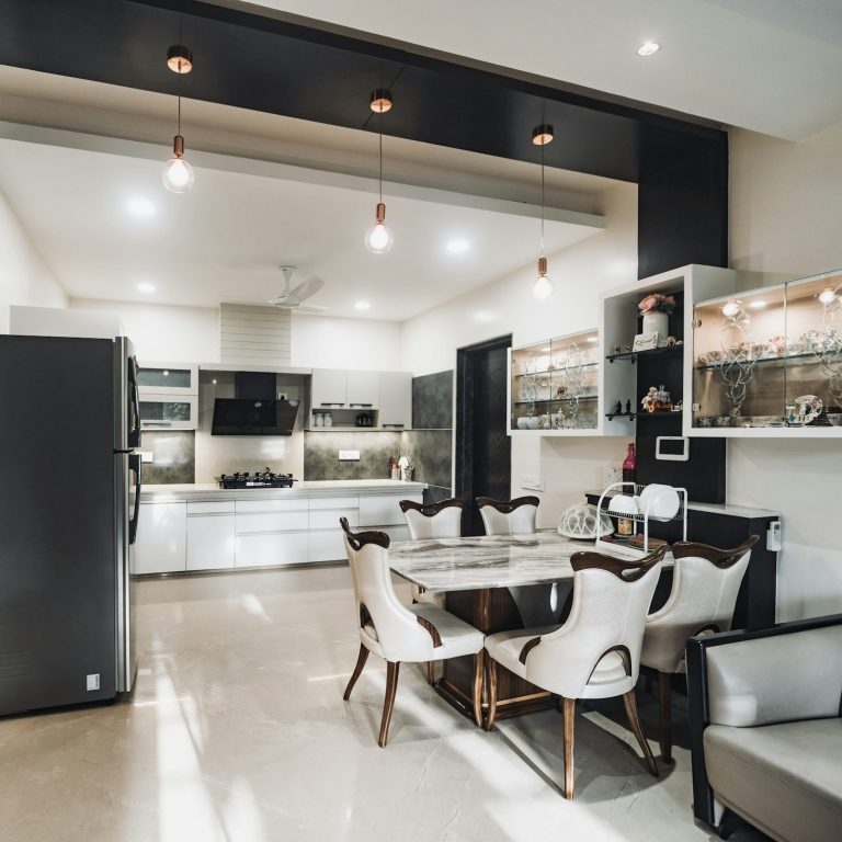 Modern kitchen and dining area with sleek furniture and bright lighting.