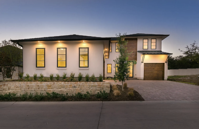 Modern house with a stylish exterior, landscaped yard, and warm outdoor lighting.
